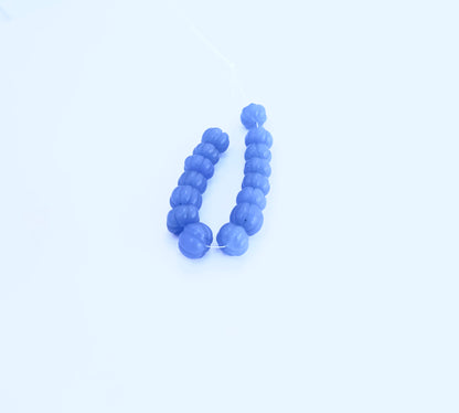 Melon cut Chalcedony beads in soft blue tones arranged vertically on a white background.