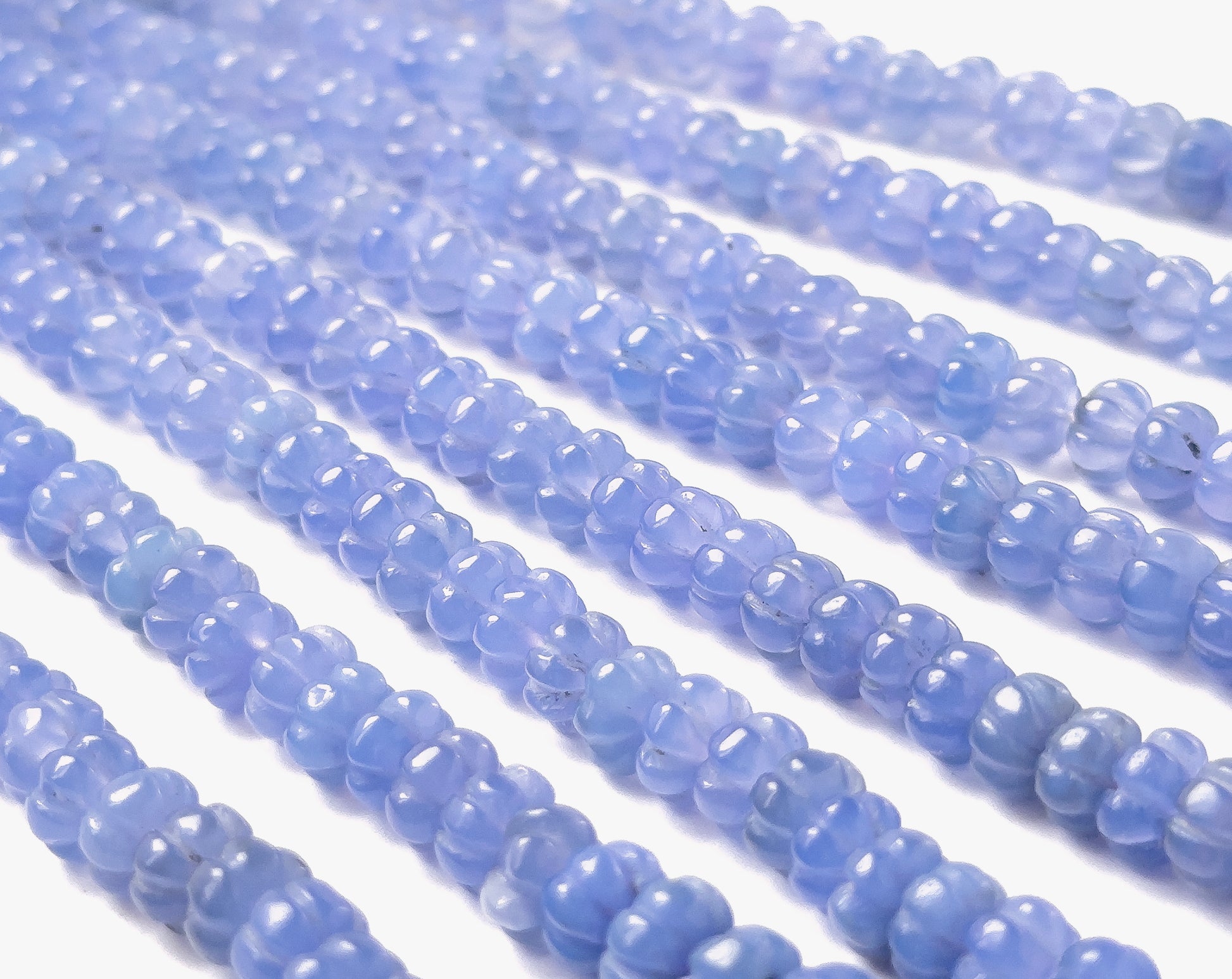 Chalcedony beads featuring smooth pumpkin‑style grooves, polished surfaces, and consistent 7.5–8mm sizing.