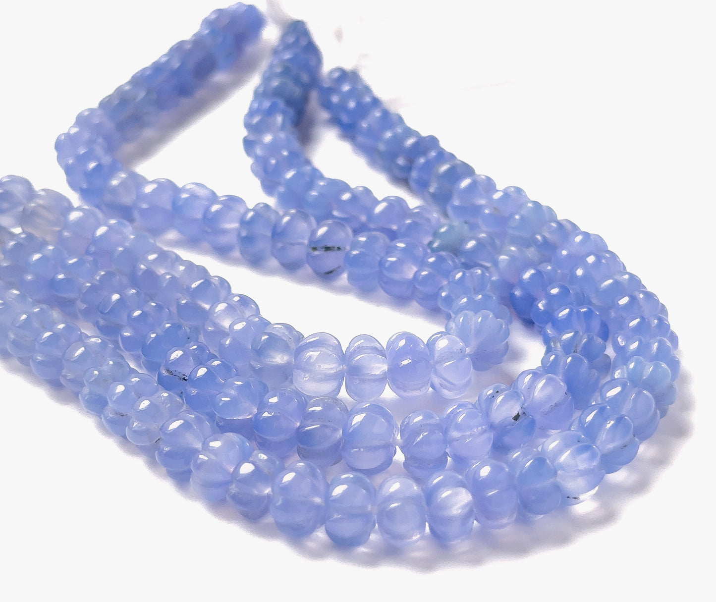 Chalcedony pumpkin‑cut beads sized 7.5–8mm arranged in a 20cm strand, showing soft translucent tones and the signature ridged pumpkin shape.