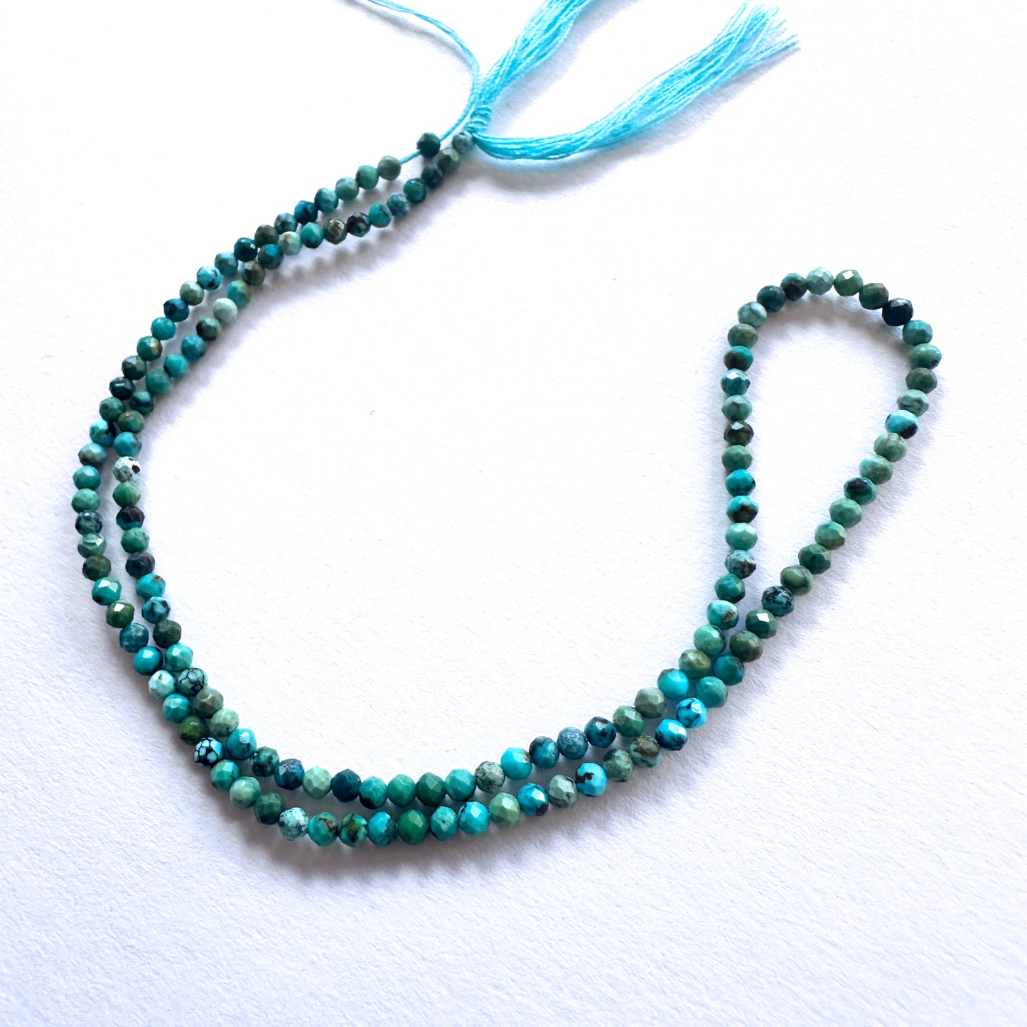 32cm strand of Chrysocolla gemstone rondelles arranged for DIY jewellery inspiration.