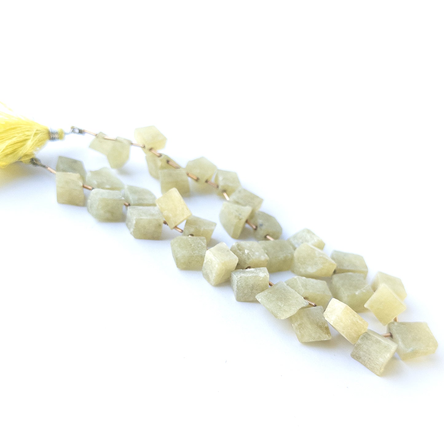 Close‑up of Chrysoberyl Cat's Eye drilled rough gemstone beads highlighting chatoyancy and raw texture.