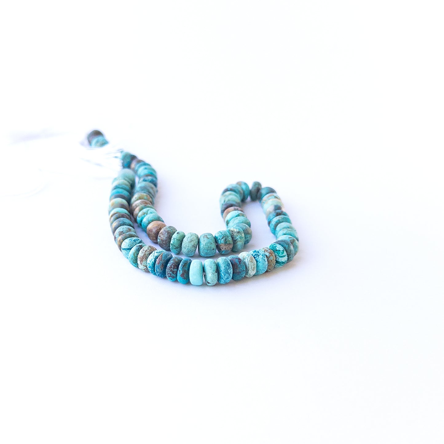 Chrysocolla smooth rondelle gemstone beads arranged in a vibrant blue‑green strand for DIY jewellery.