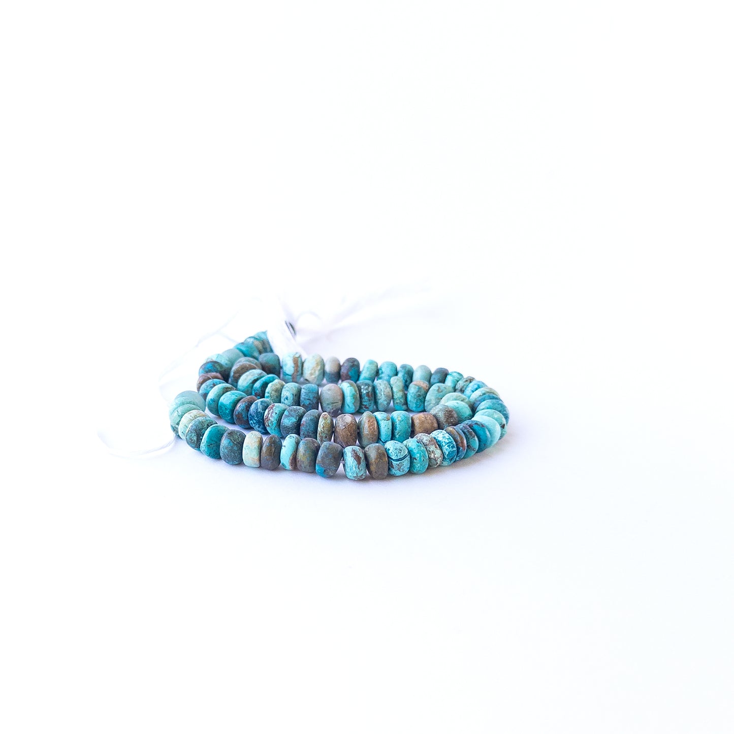 Close‑up of Chrysocolla rondelle beads showing their shine, clarity, and organic texture.