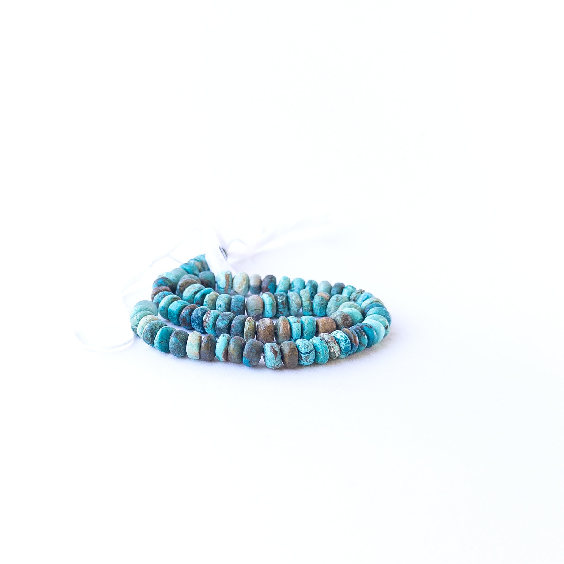 Close‑up of Chrysocolla rondelle beads showing their shine, clarity, and organic texture.