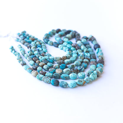 Close‑up of genuine Chrysocolla smooth tumble beads showing their rich colour mix and polished finish.