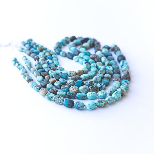 Close‑up of genuine Chrysocolla smooth tumble beads showing their rich colour mix and polished finish.