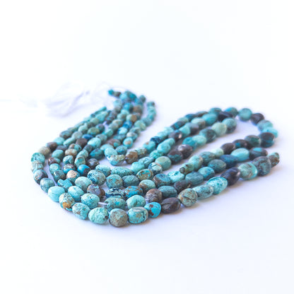 Chrysocolla smooth tumble beads displaying earthy blue‑green tones and natural texture.