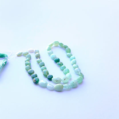 Vibrant green Chrysoprase faceted oval beads aligned on a strand highlighting clarity, cut quality and smooth finish.