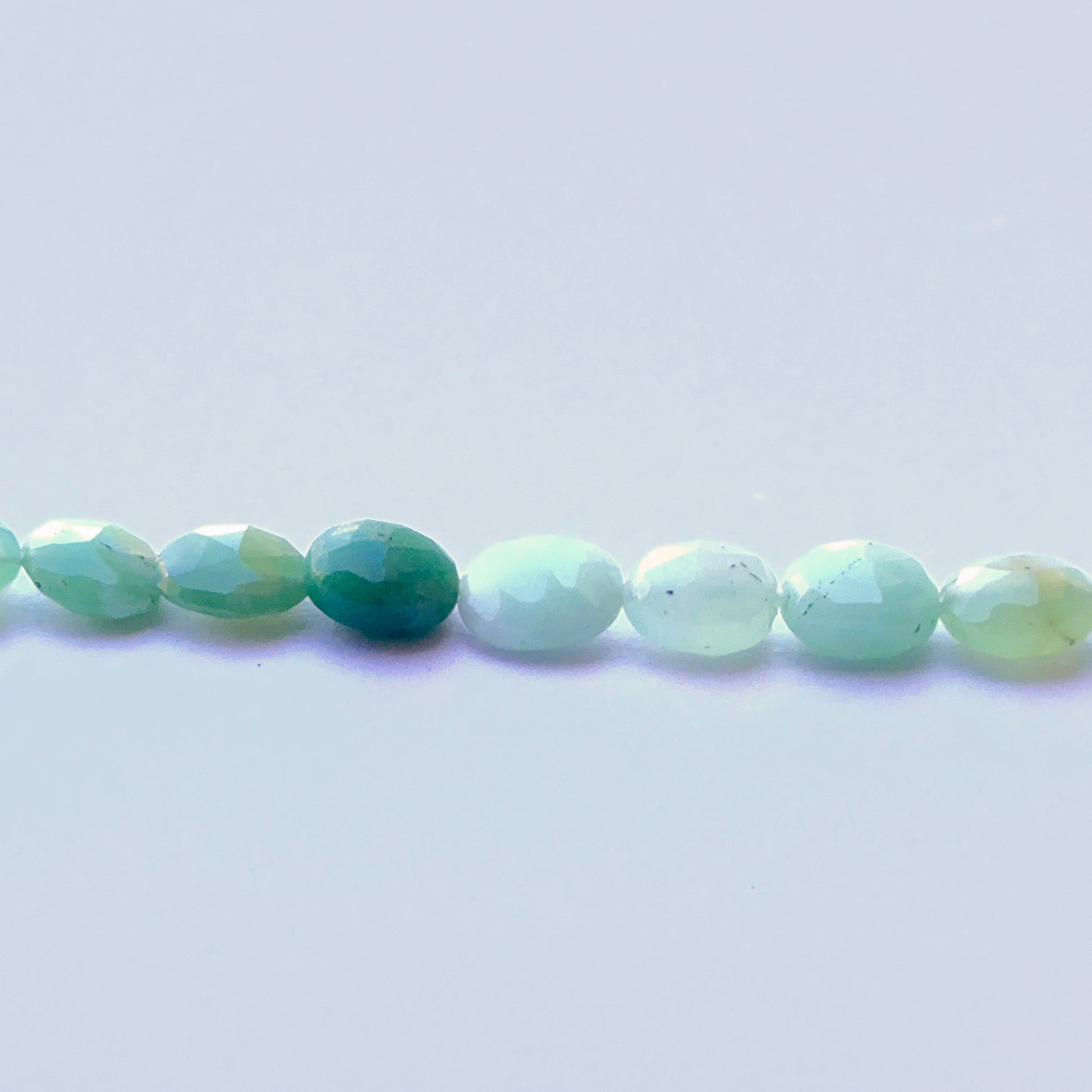 Delicate strands of Chrysoprase beads, showcasing their faceted design.