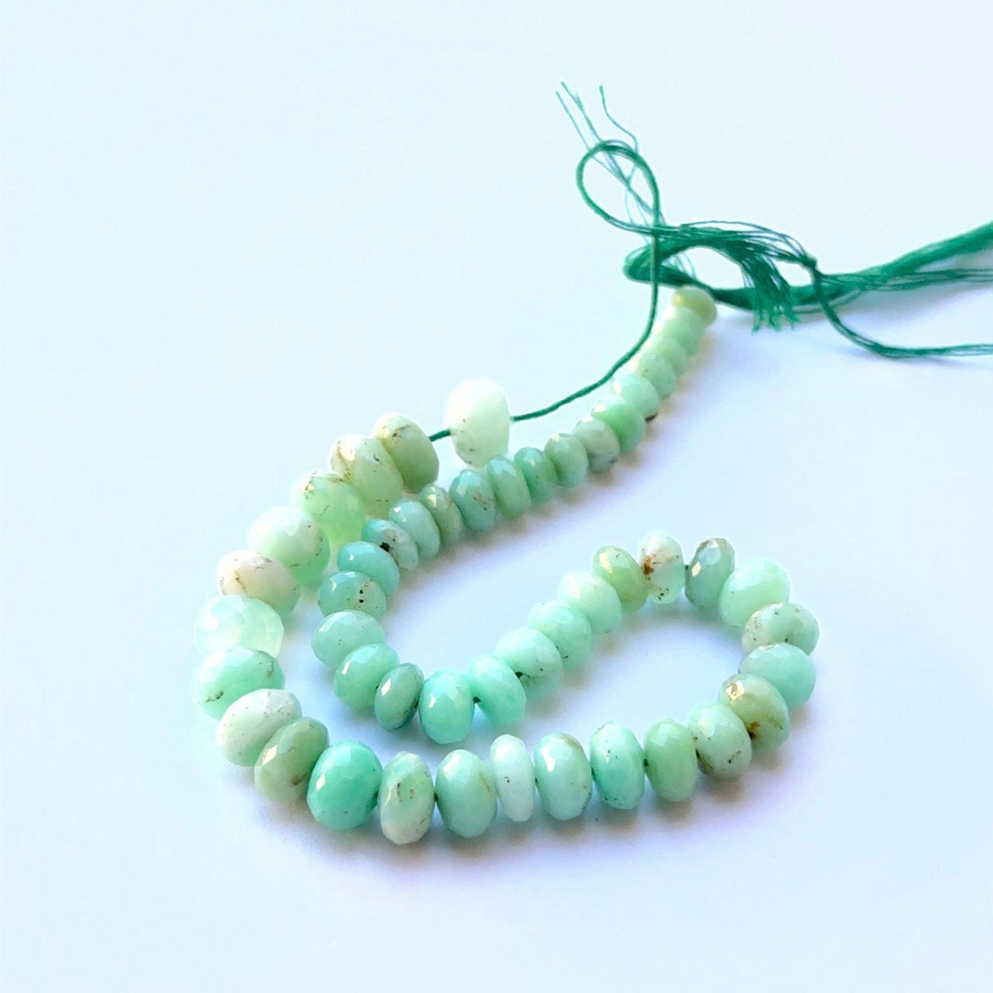 Detailed view of premium Chrysoprase stone beads showing natural inclusions, polished facets and vibrant green hues.