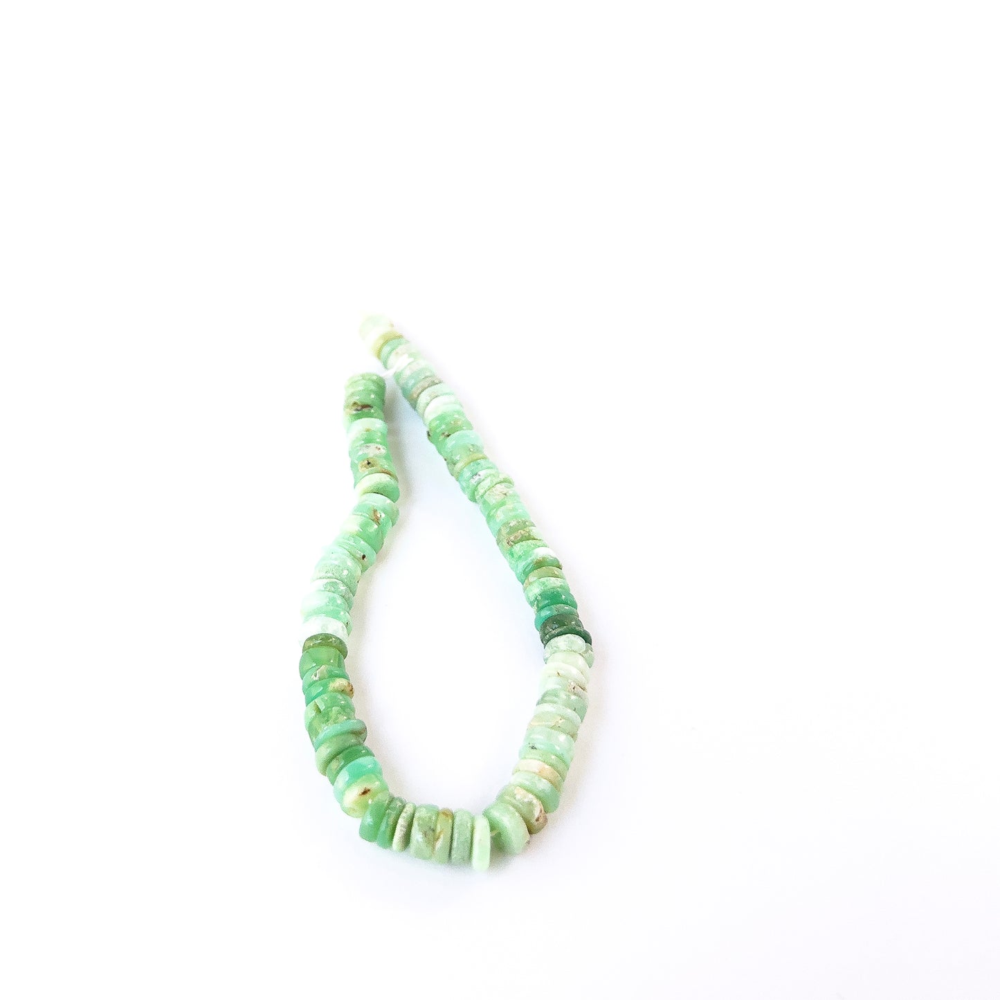 Chrysoprase smooth wheel beads in fresh green tones arranged on a strand for handmade jewellery components.