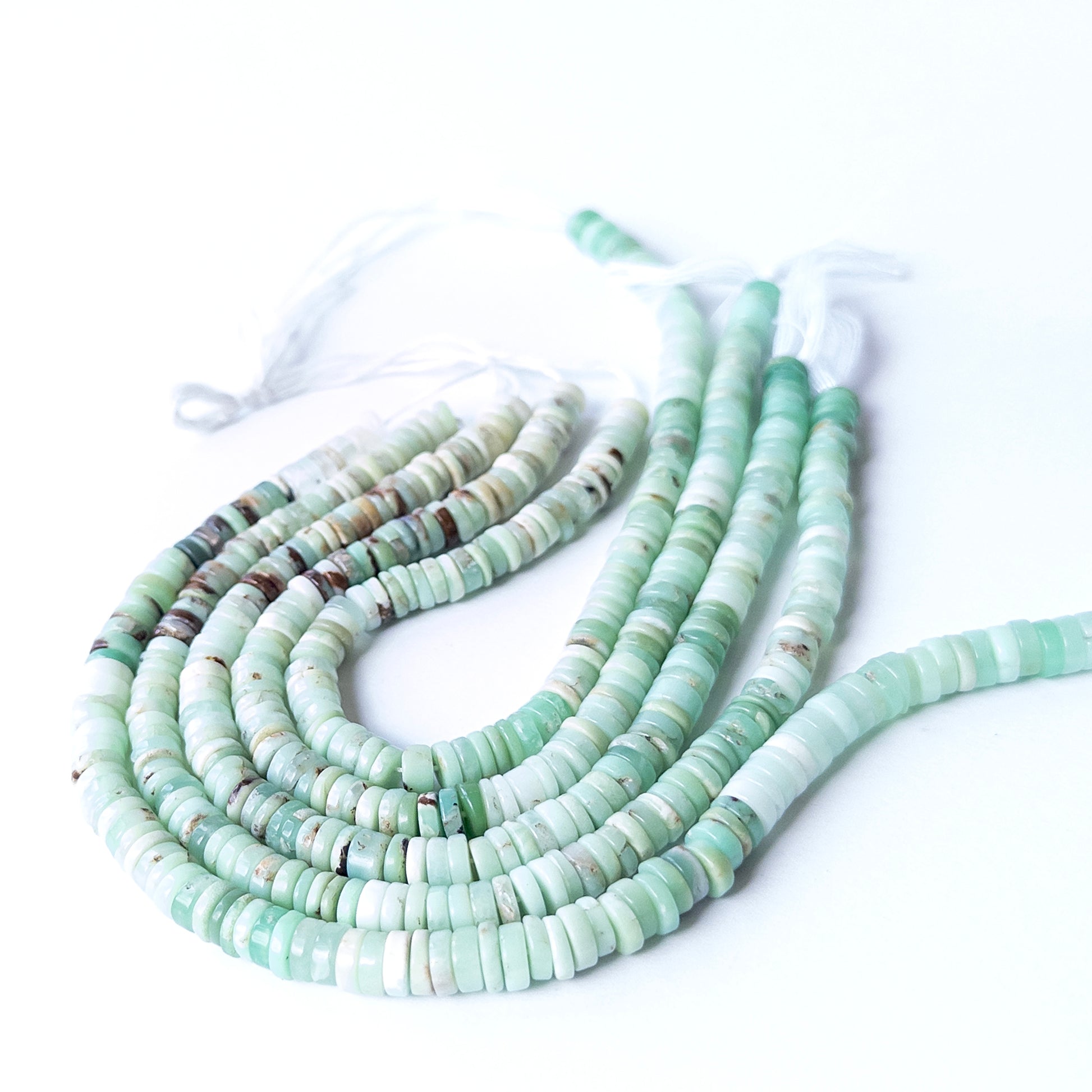 Close‑up of genuine Chrysoprase wheel heishi stone beads with clean shaping and vibrant green tone.
