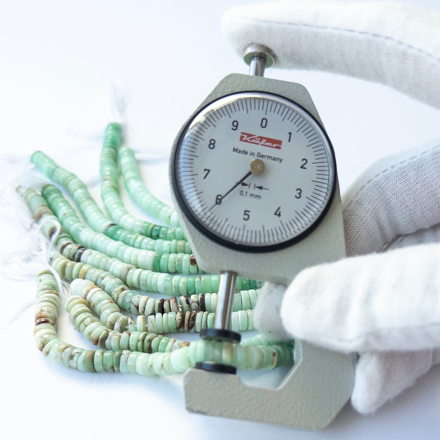 A dial gauge measures the Chrysoprase smooth wheel 5.9–6mm gemstone.