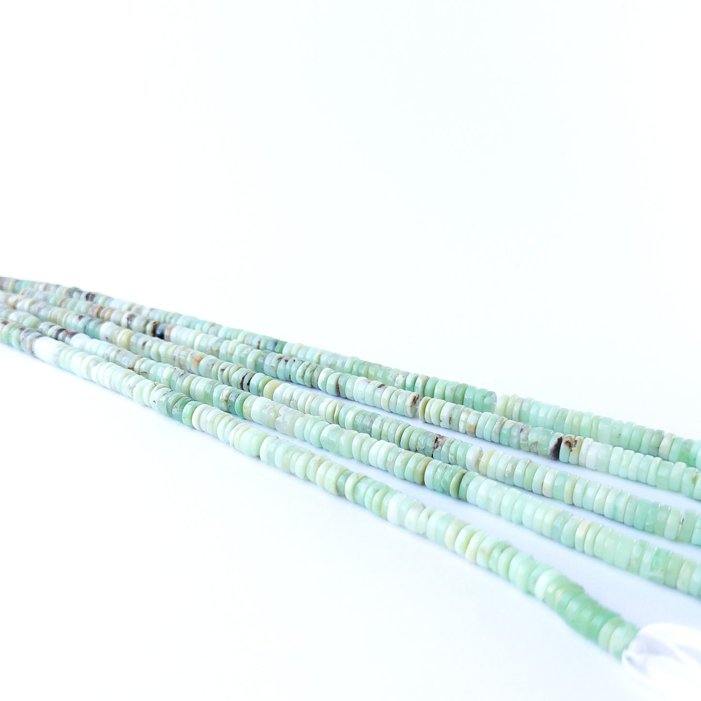 Close‑up of genuine Chrysoprase smooth wheel beads showing polished shine and natural pastel green tones.