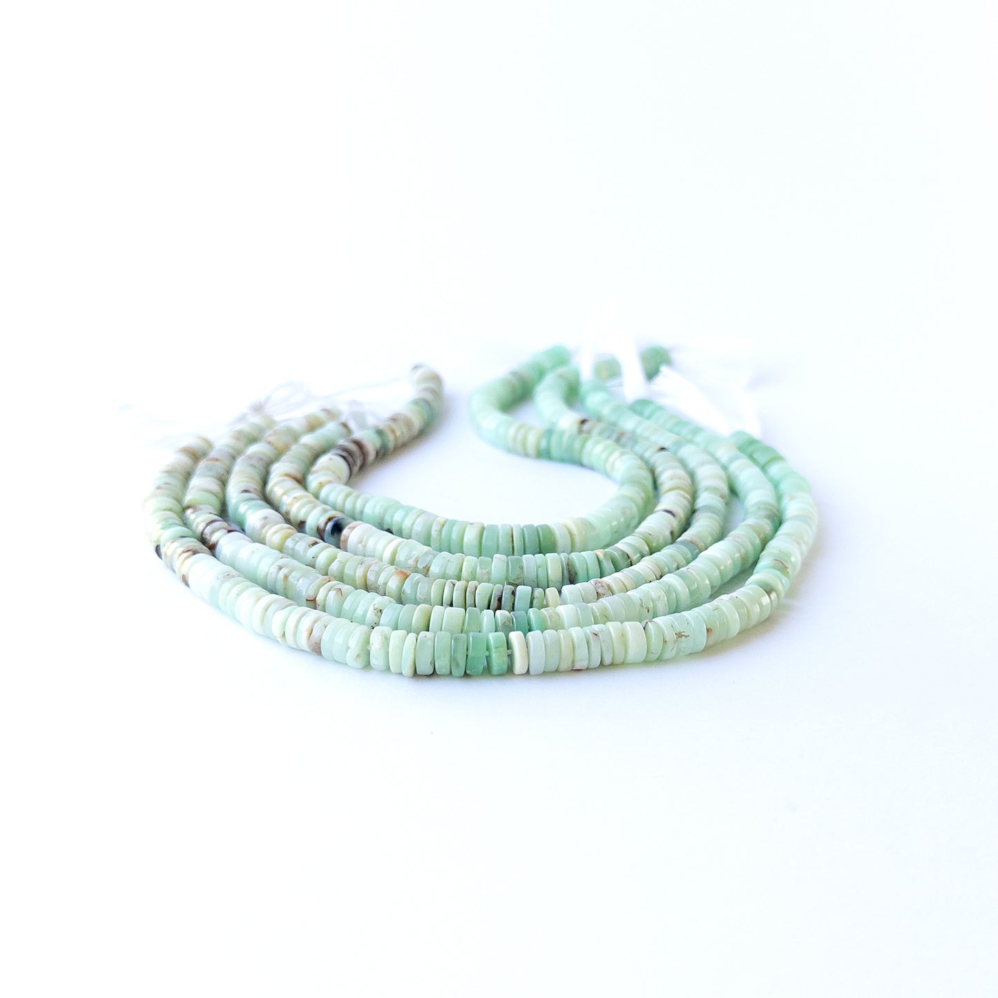 Handmade jewellery components featuring smooth Chrysoprase wheel beads in a neatly arranged strand.
