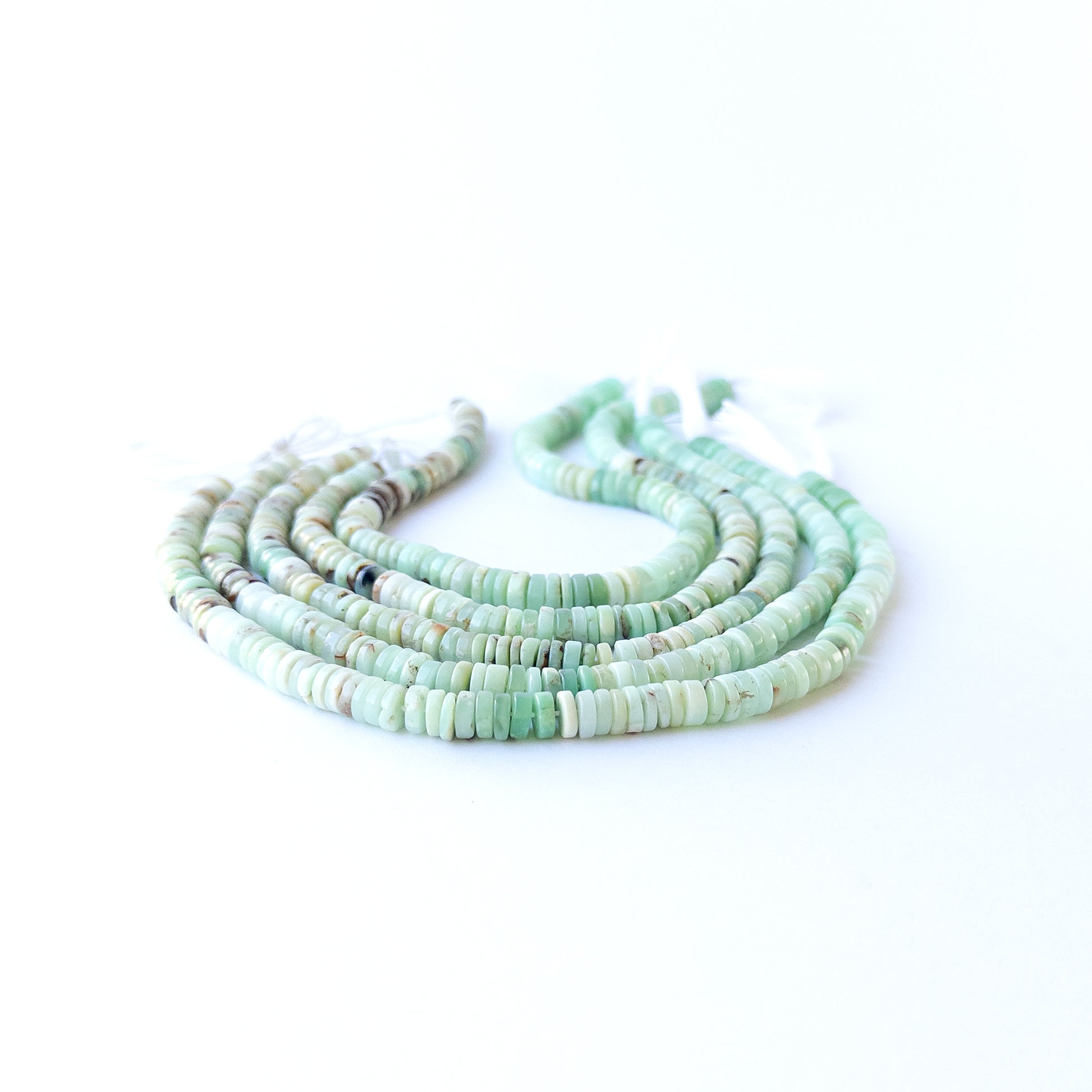 Handmade jewellery components featuring smooth Chrysoprase wheel beads in a neatly arranged strand.