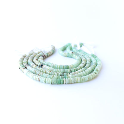 Handmade jewellery components featuring smooth Chrysoprase wheel beads in a neatly arranged strand.