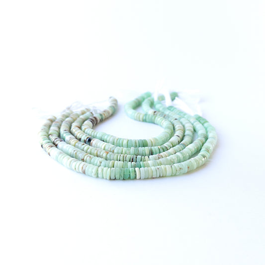 Handmade jewellery components featuring smooth Chrysoprase wheel beads in a neatly arranged strand.