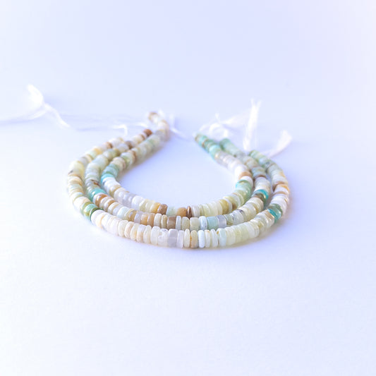 Close‑up of genuine chrysoprase smooth wheel gemstone beads with natural shine for DIY jewellery making.