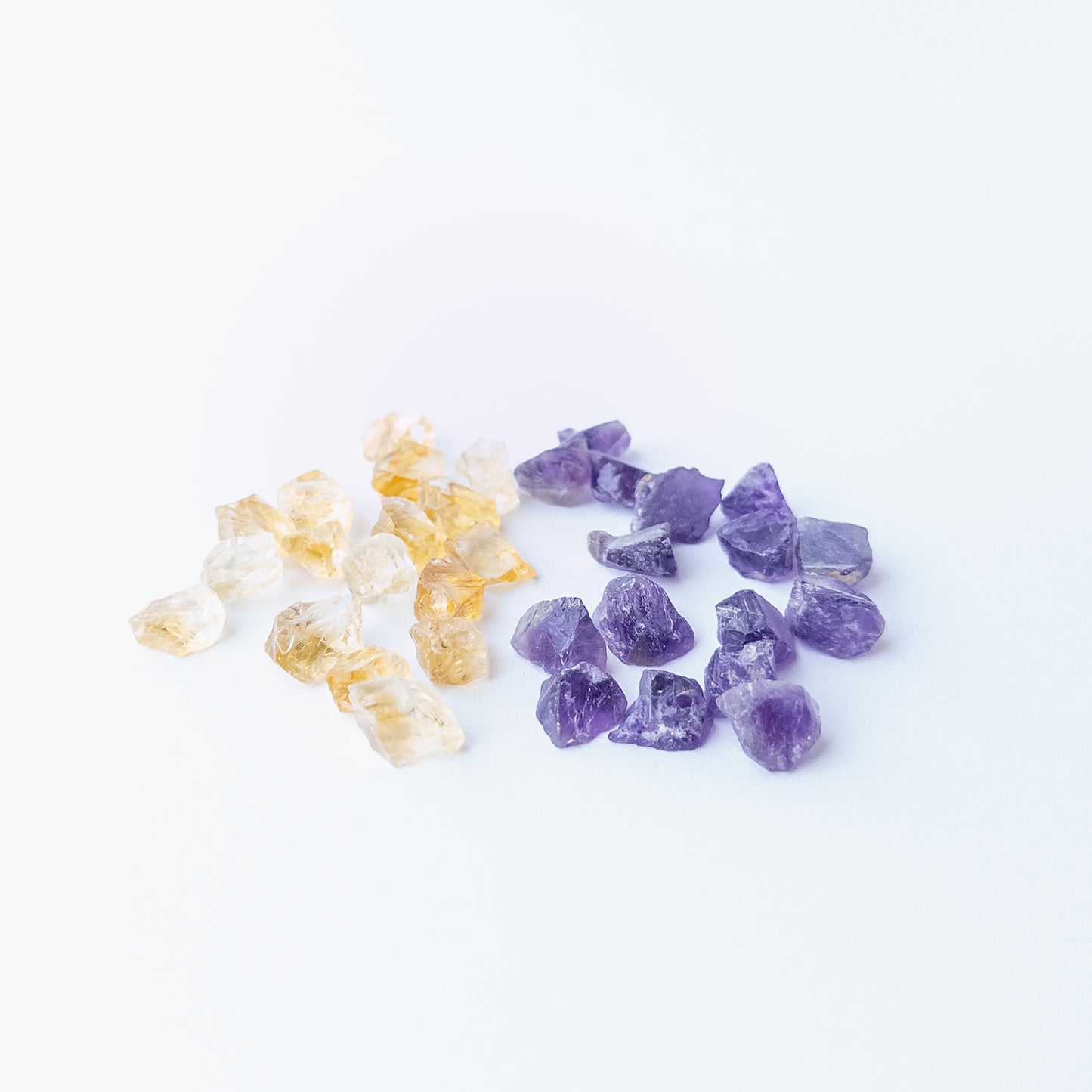 Mixed Citrine and Amethyst rough stones arranged together showing vivid colour contrast and raw beauty.