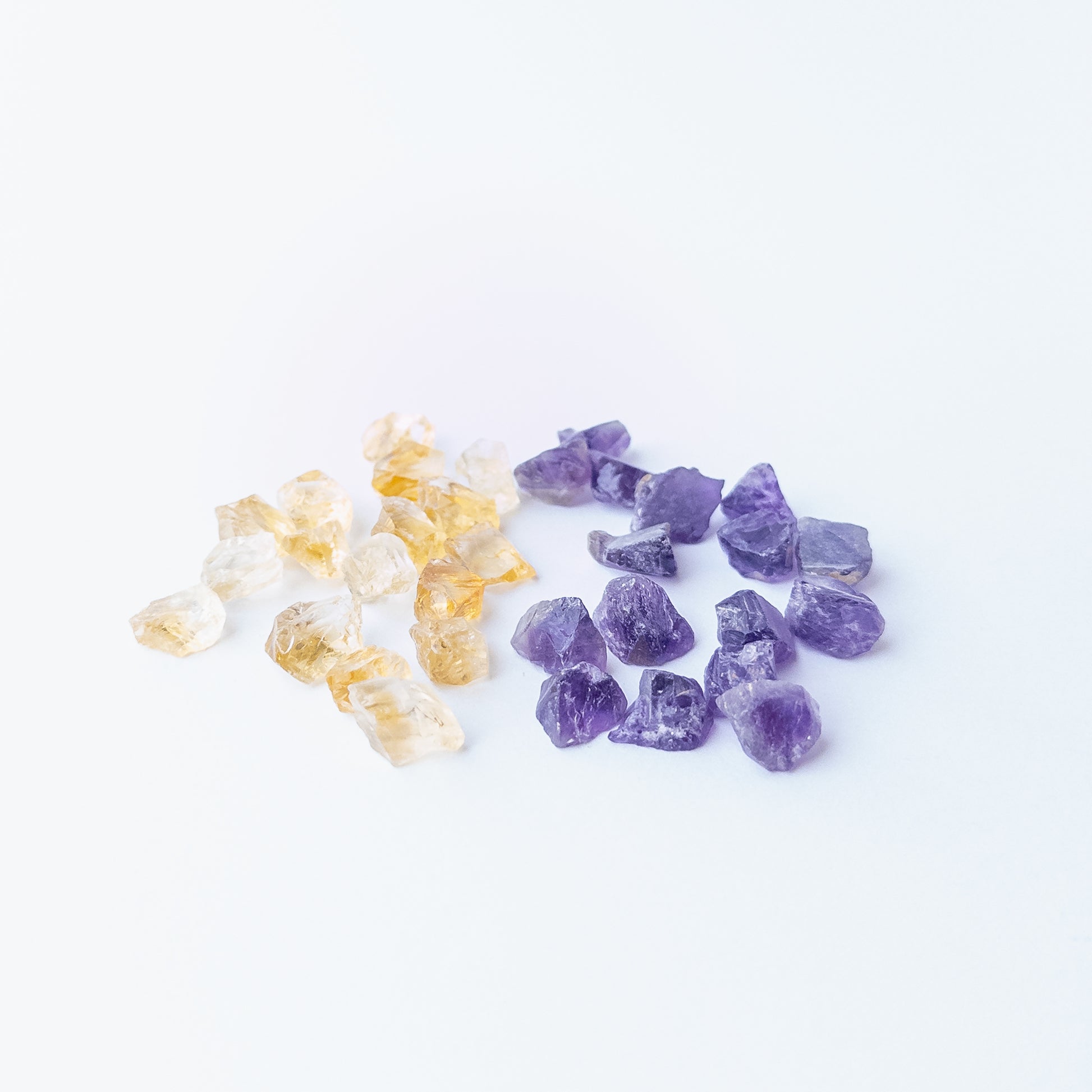 Mixed Citrine and Amethyst rough stones arranged together showing vivid colour contrast and raw beauty.