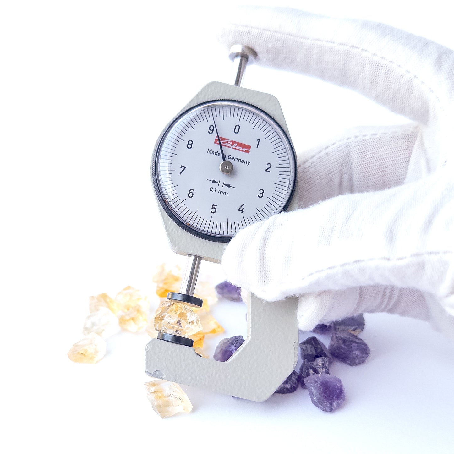 A dial gauge measures the Citrine and Amethyst rough 9–11mm gemstone.