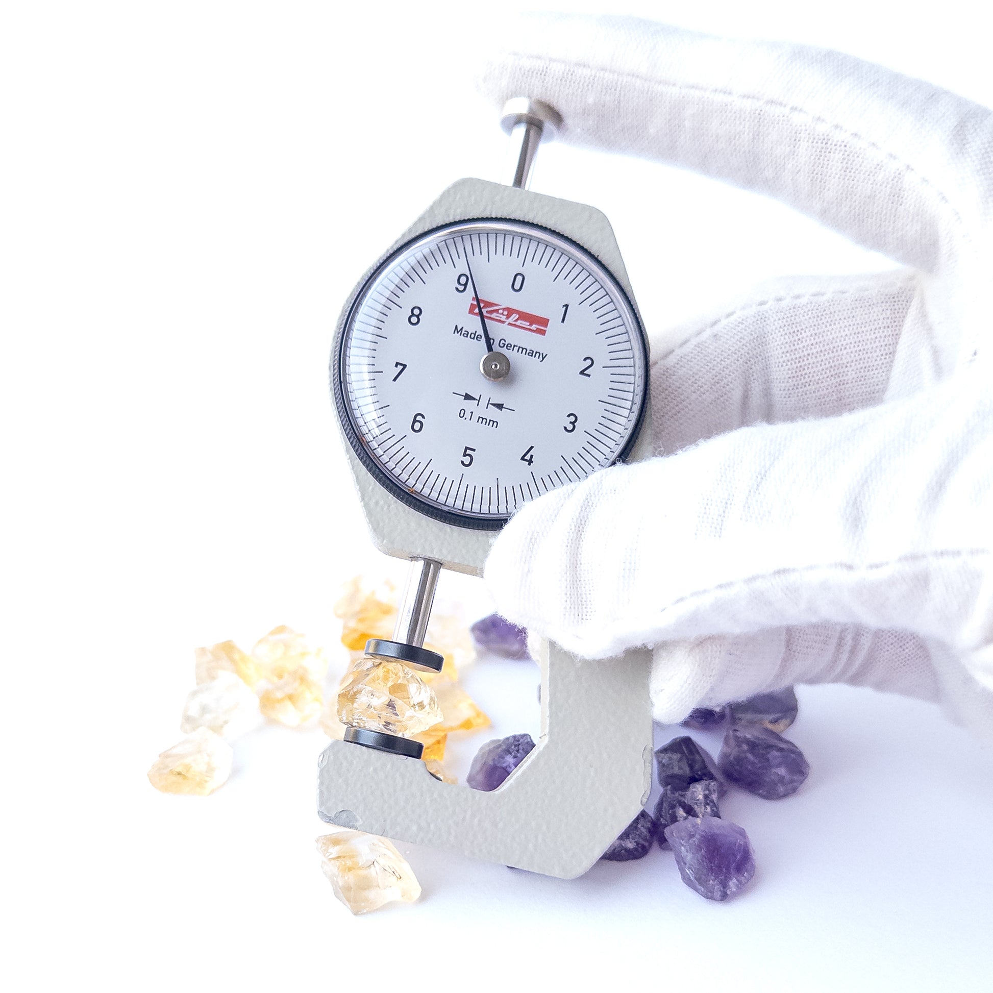 A dial gauge measures the Citrine and Amethyst rough 9–11mm gemstone.