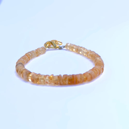 Close-up of polished citrine stone beads arranged in a radiant bracelet.