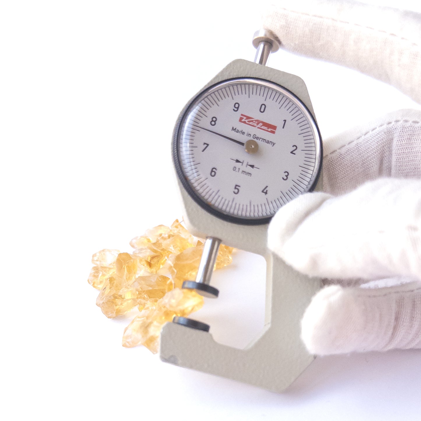 A dial gauge measures the Citrine drilled rough 5.5–9.5mm gemstone.