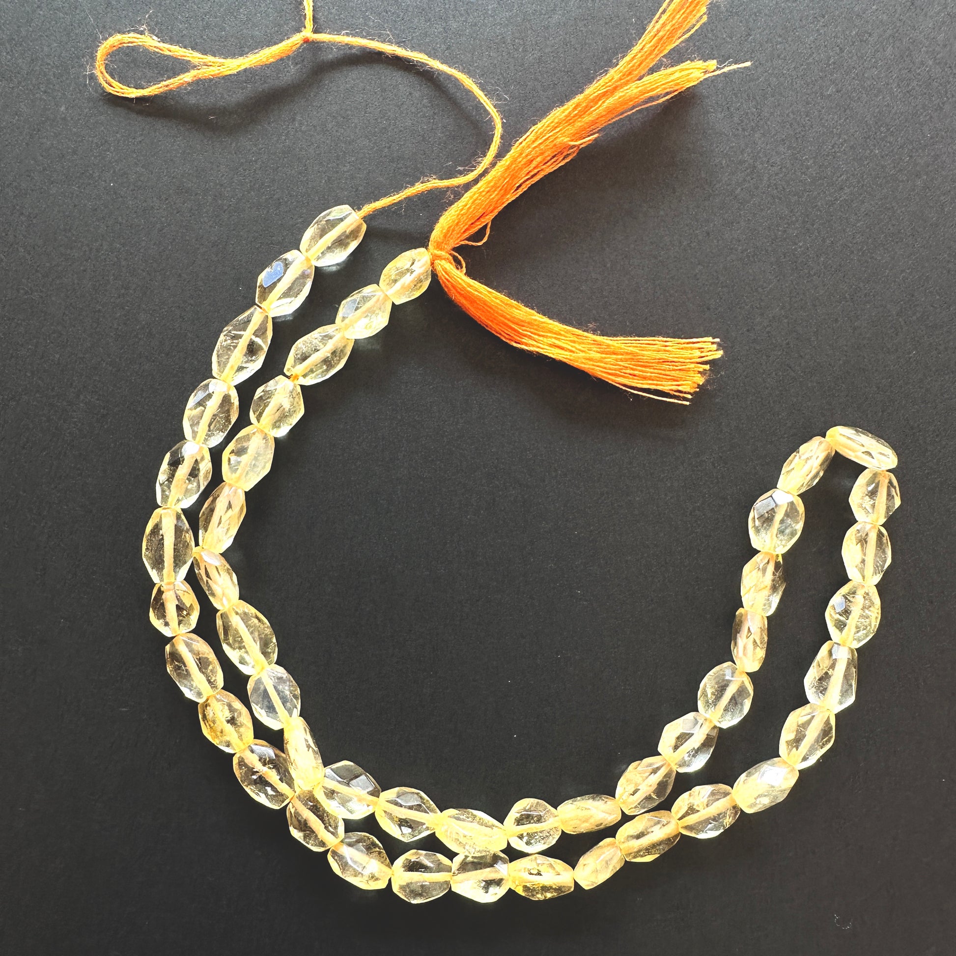 Close-up of Citrine beads showcasing their sparkle and oval cut.