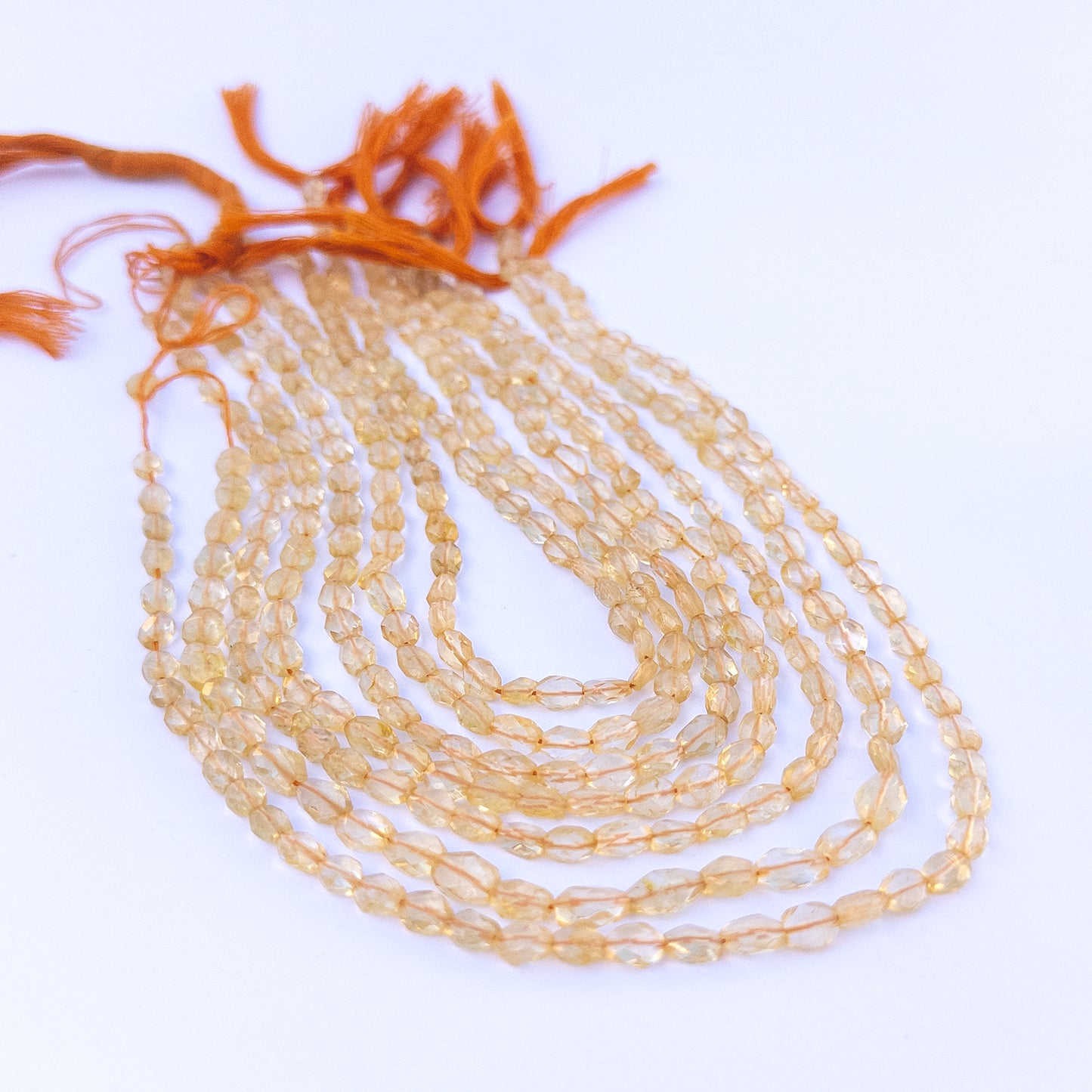 Authentic citrine stone beads in faceted oval cuts showing polished shine and clarity for jewellery design work.