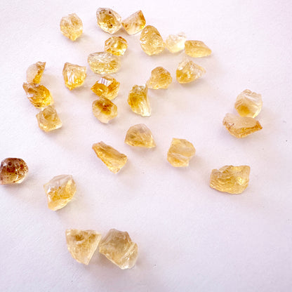 Citrine stones arranged in a flat lay, highlighting their uncut form and warm glow.