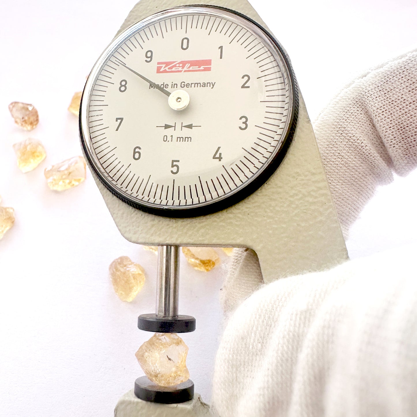 A dial gauge measures the Citrine rough cut 8mm gemstone.