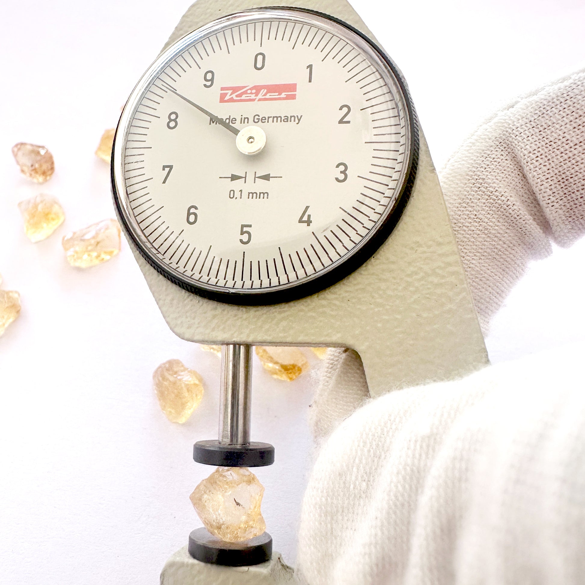 A dial gauge measures the Citrine rough cut 8mm gemstone.