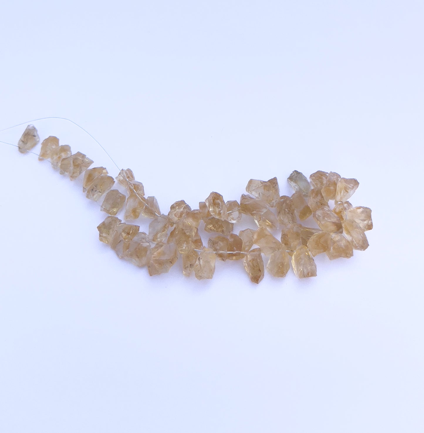  Close-up of 57 Citrine stone beads featuring drilled holes and raw crystal texture. 