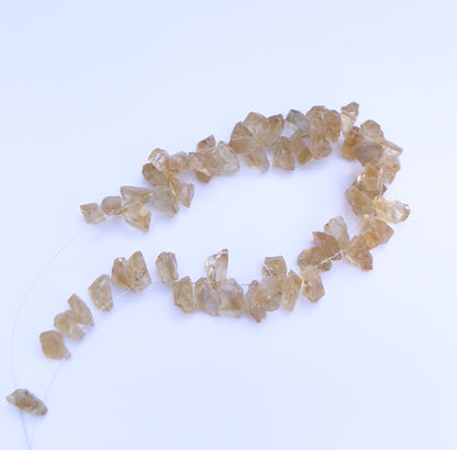 Handmade jewellery components with drilled Citrine beads in irregular shapes and warm tones.