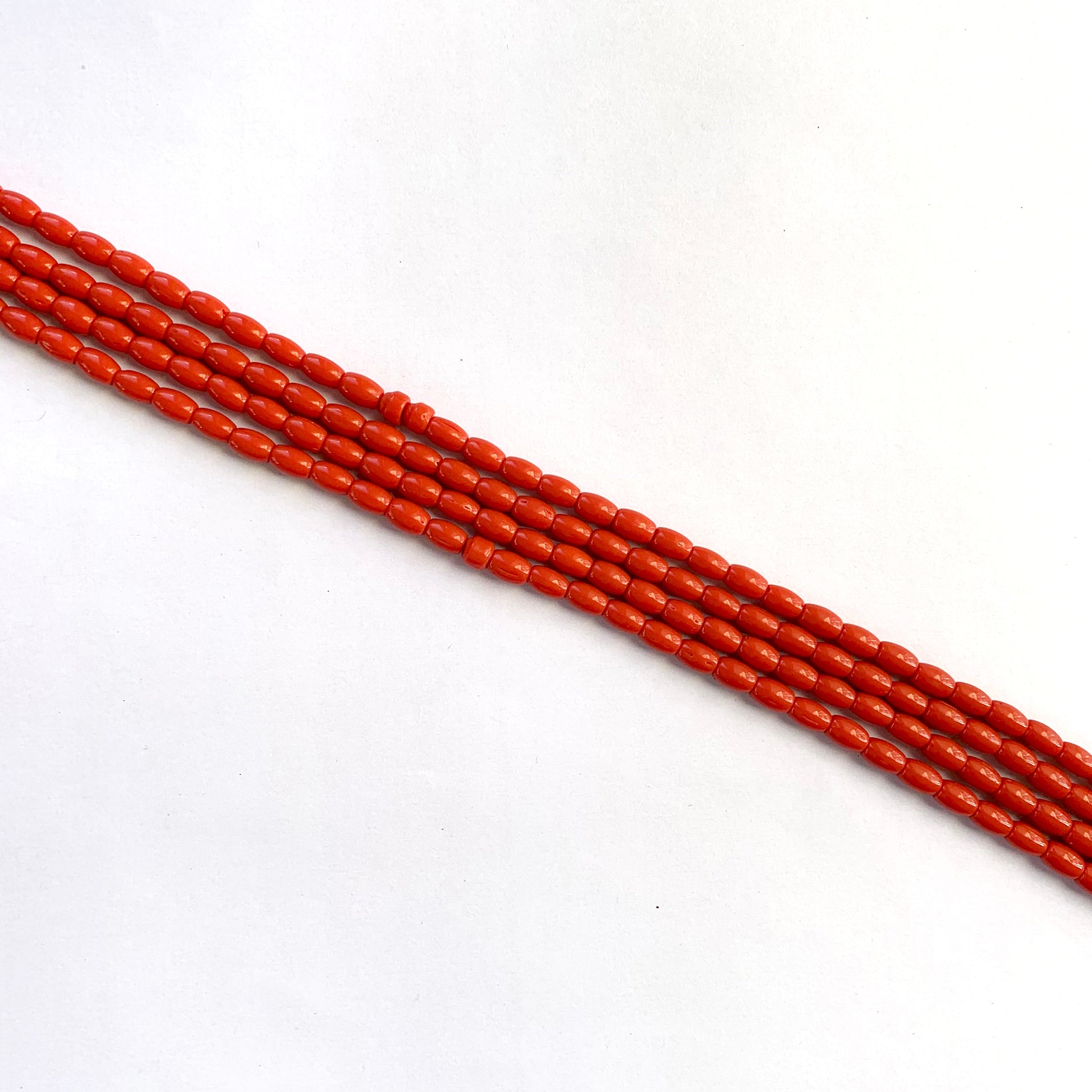 Smooth coral gemstones with natural drum shape ranging from 6.4x4.1mm to 6.7x4.4mm.