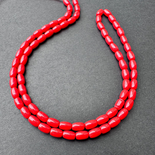 Coral smooth drum beads with rich red tones arranged on a 37cm strand for jewellery making.