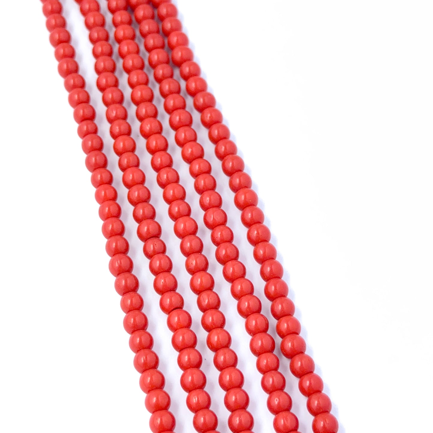 Smooth round Taiwan Coral stone beads showing vibrant colour and handmade jewellery component quality.