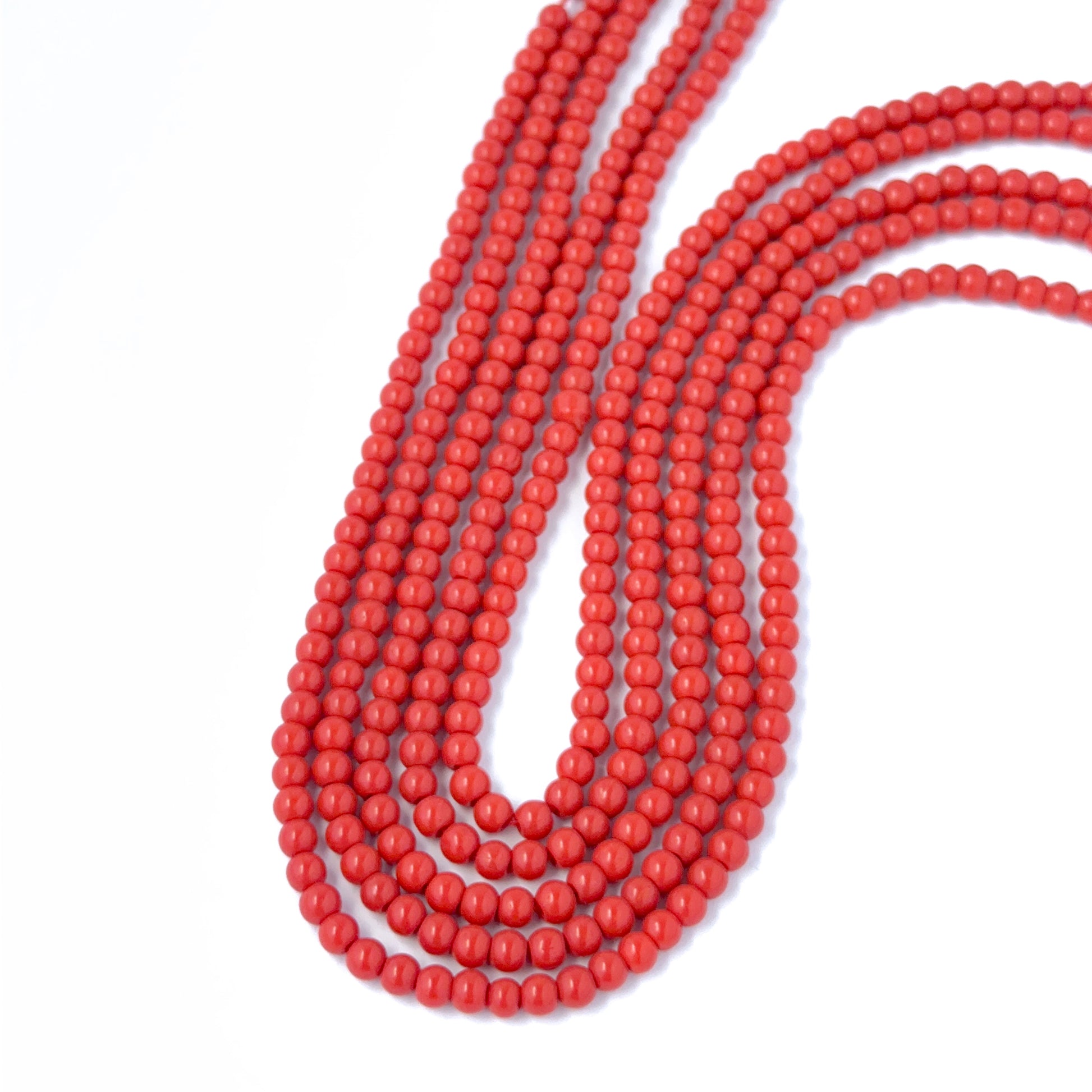 Close‑up of Taiwan Coral round beads showing detailed surface texture and  gemstone colour.
