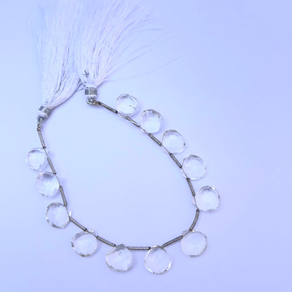 Crystal gemstone beads laid flat to highlight their faceted surface and heart briolette shape.