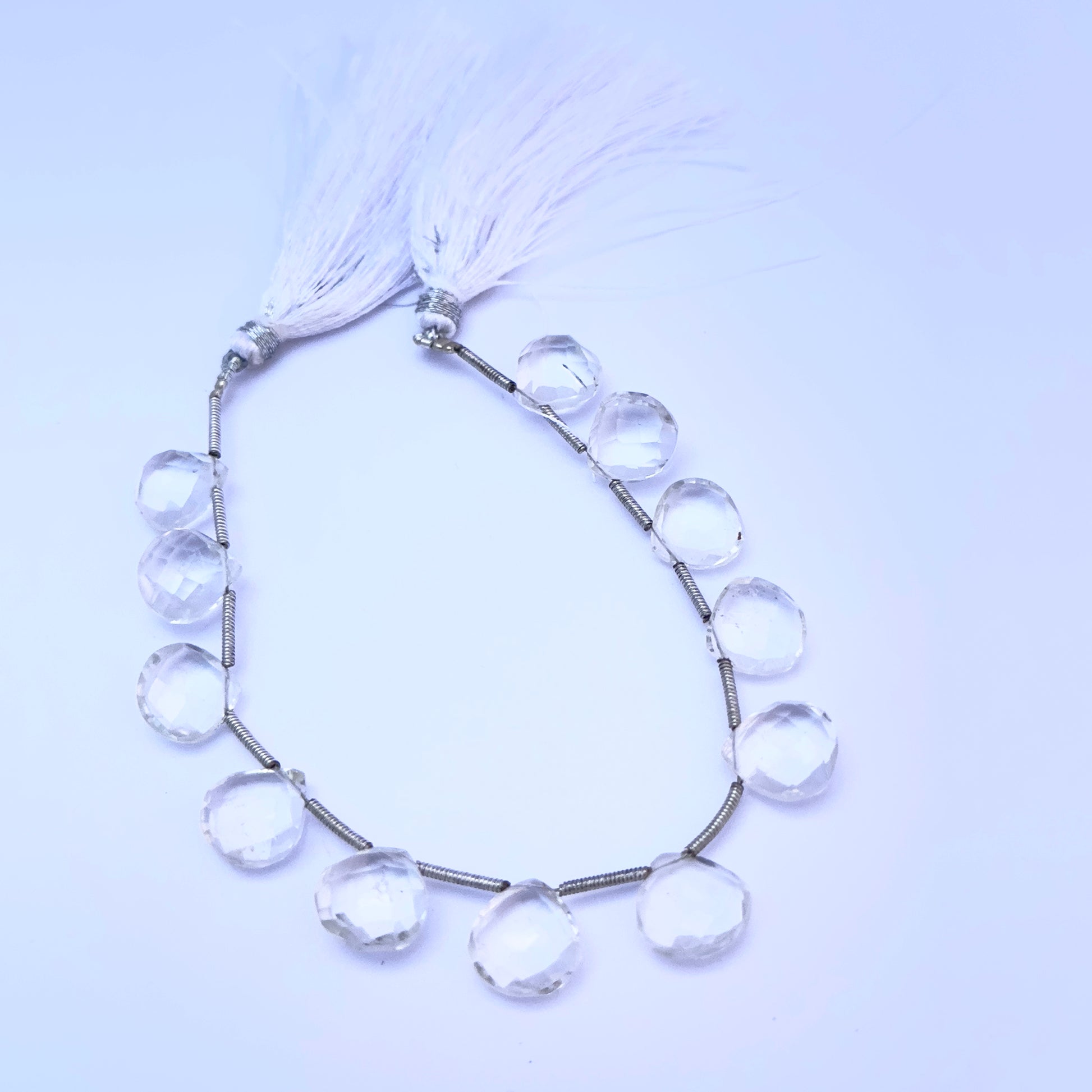 Natural gemstone beads in Crystal heart briolette cut, ideal for DIY jewellery and artisan designs.