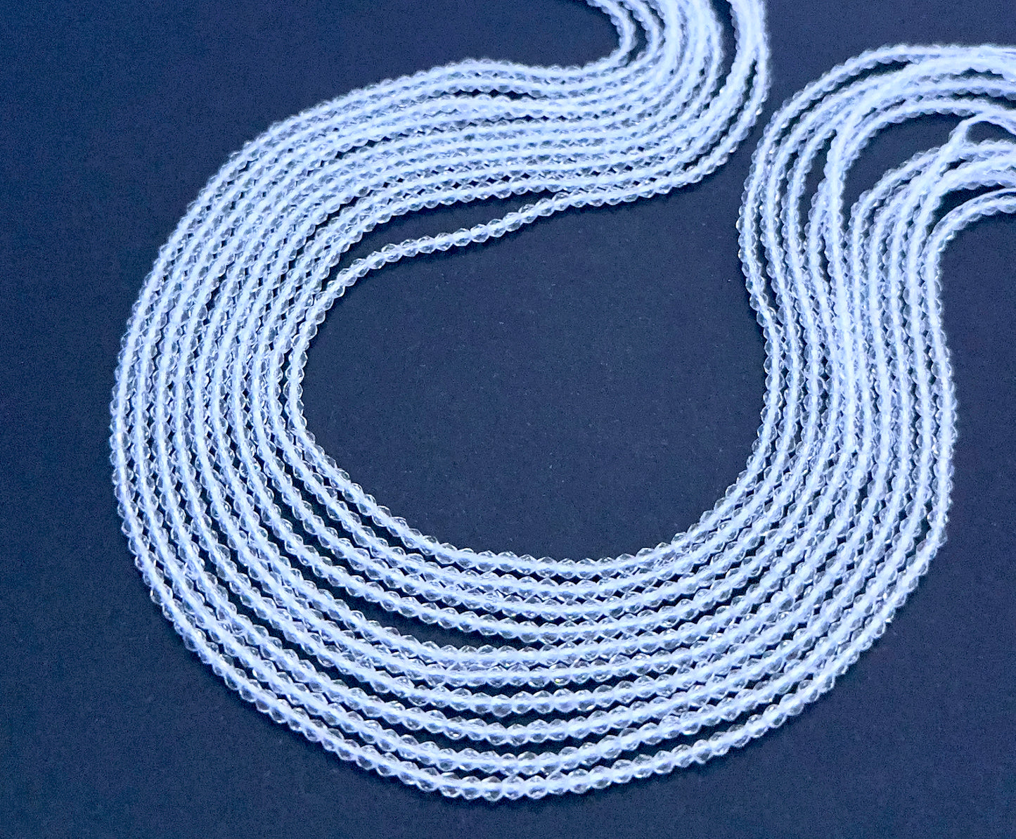 Crystal gemstone beads laid flat to highlight their faceted surface and uniform size.