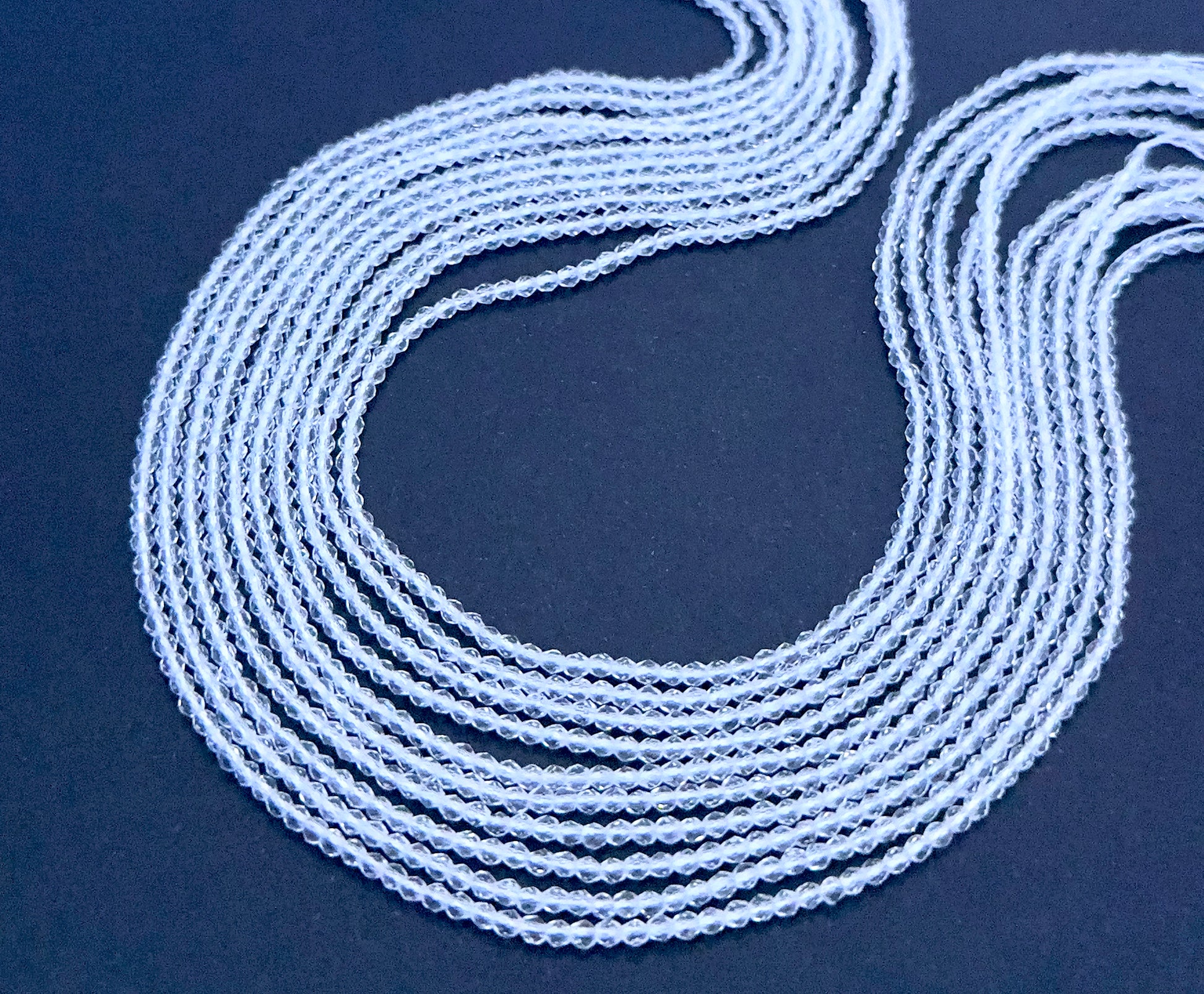 Crystal gemstone beads laid flat to highlight their faceted surface and uniform size.