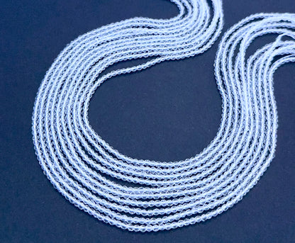 Crystal gemstone beads laid flat to highlight their faceted surface and uniform size.