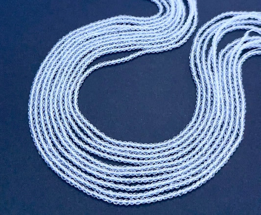 Crystal gemstone beads laid flat to highlight their faceted surface and uniform size.