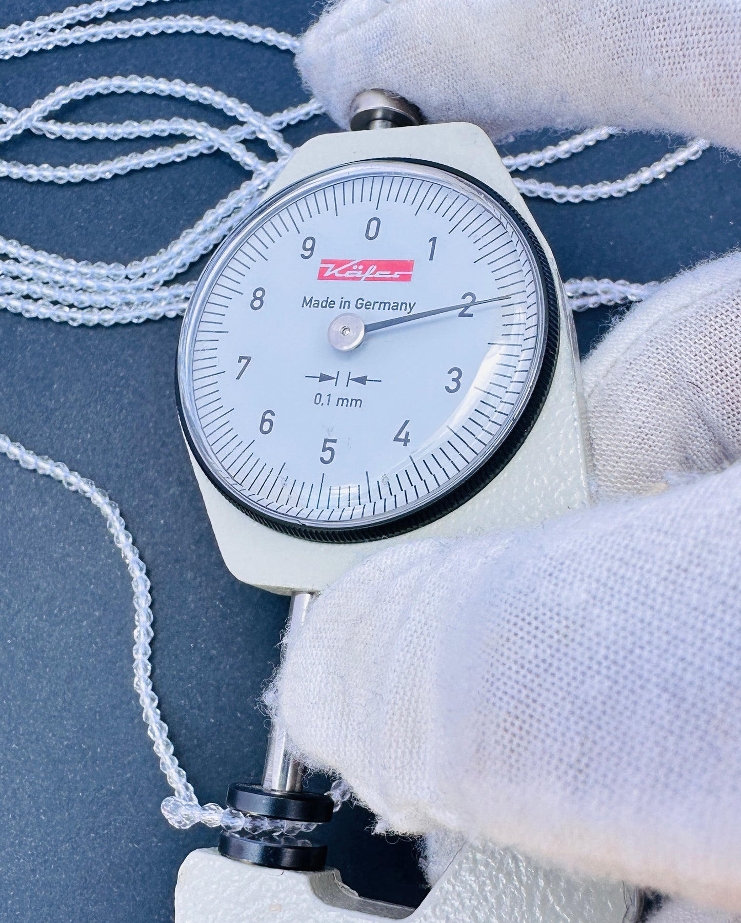 A dial gauge measures the Crystal faceted rondelle 2.2mm gemstone.