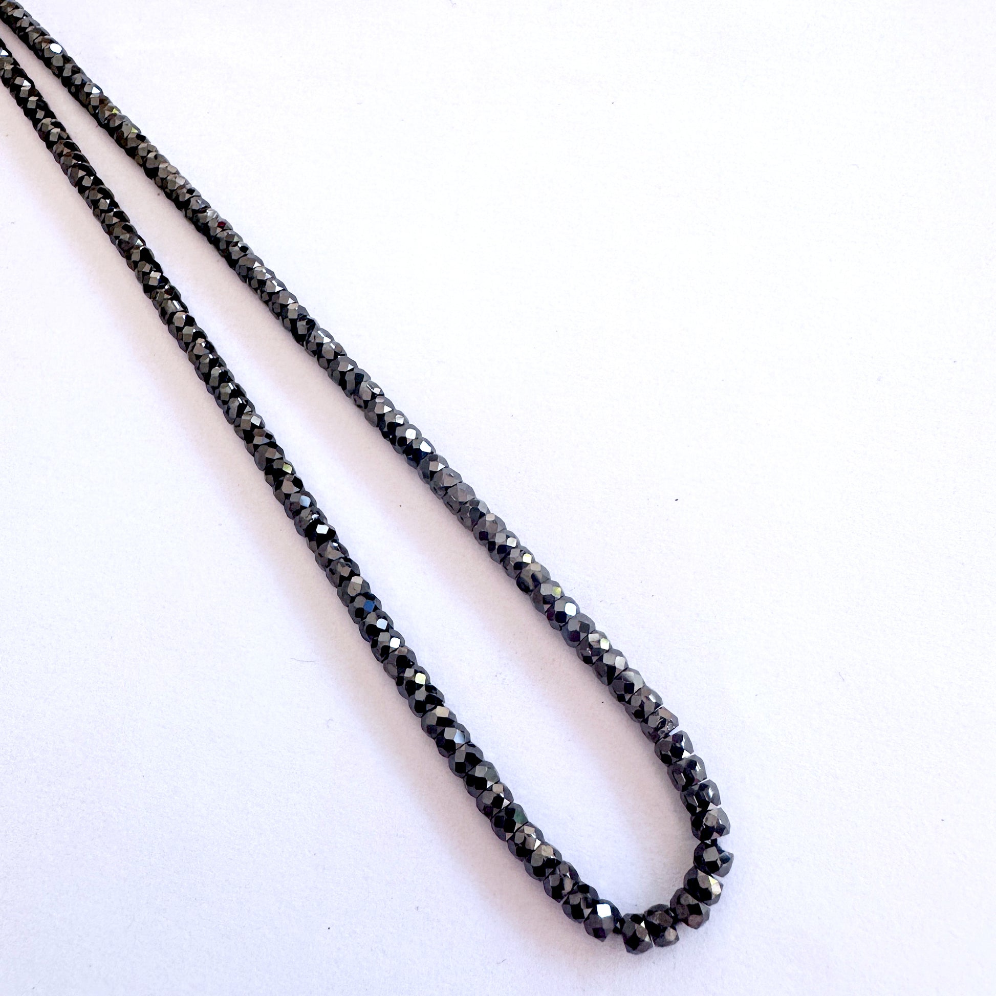 Jet-black faceted Cubic Zirconia gemstones with consistent rondelle cut and elegant shine.