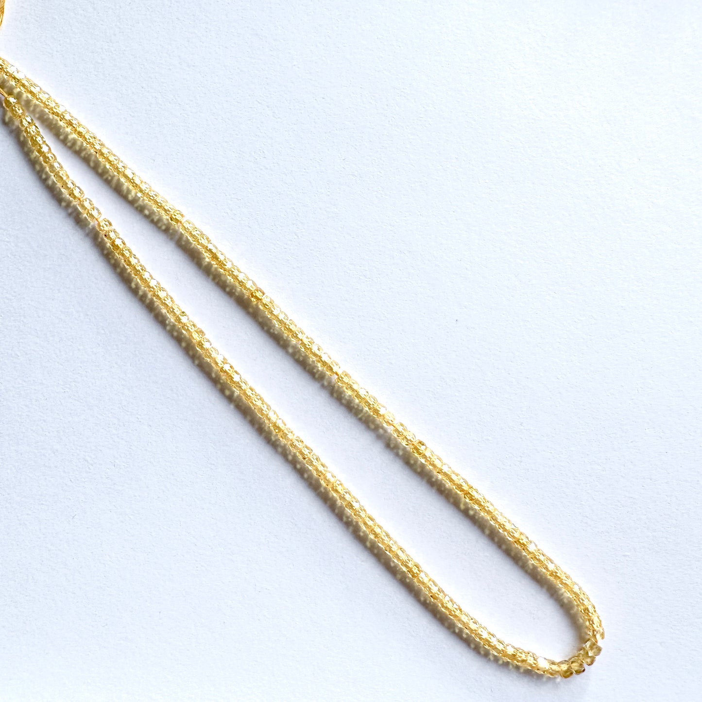 Yellow Cubic Zirconia rondelle beads with faceted cut arranged on a 32cm strand.