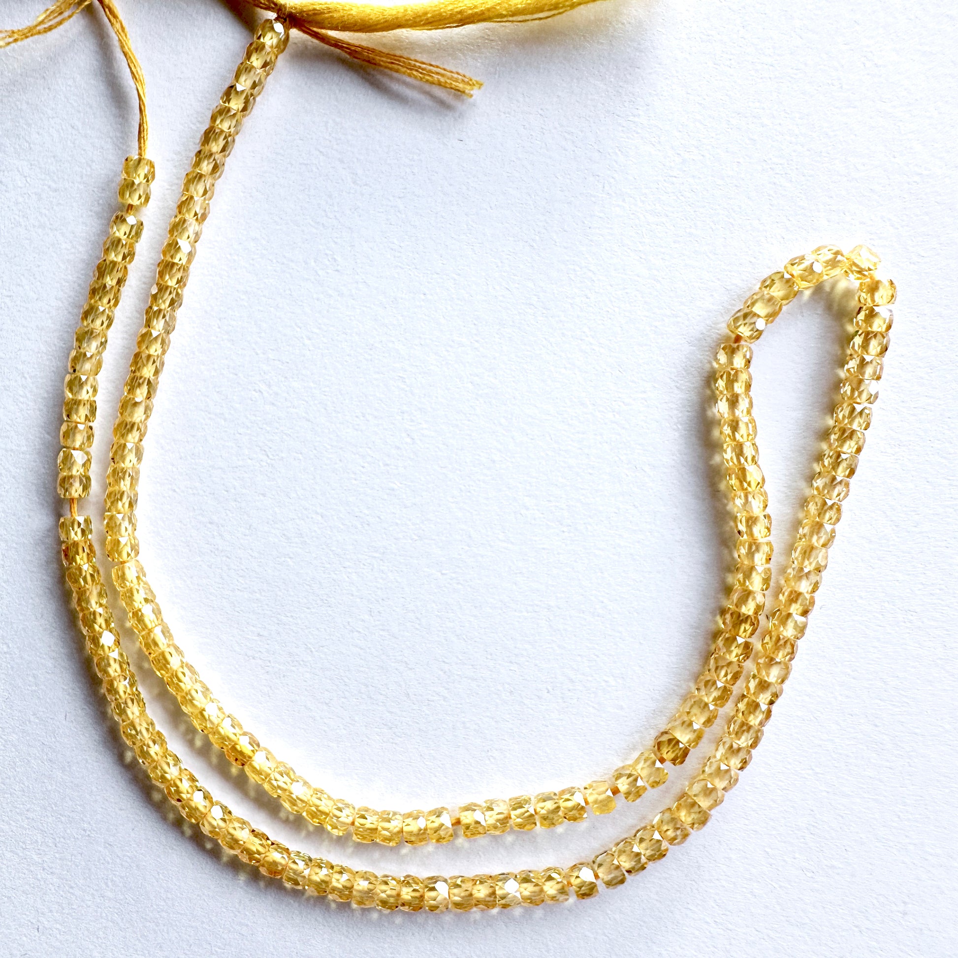 Close-up of 3mm Yellow Cubic Zirconia beads showing brilliant sparkle and clarity.